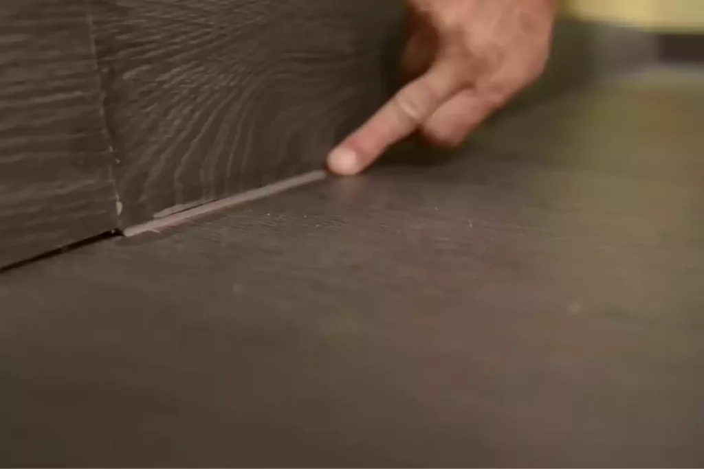 Application d'un joint acrylique pour combler l'espace entre plinthe et parquet