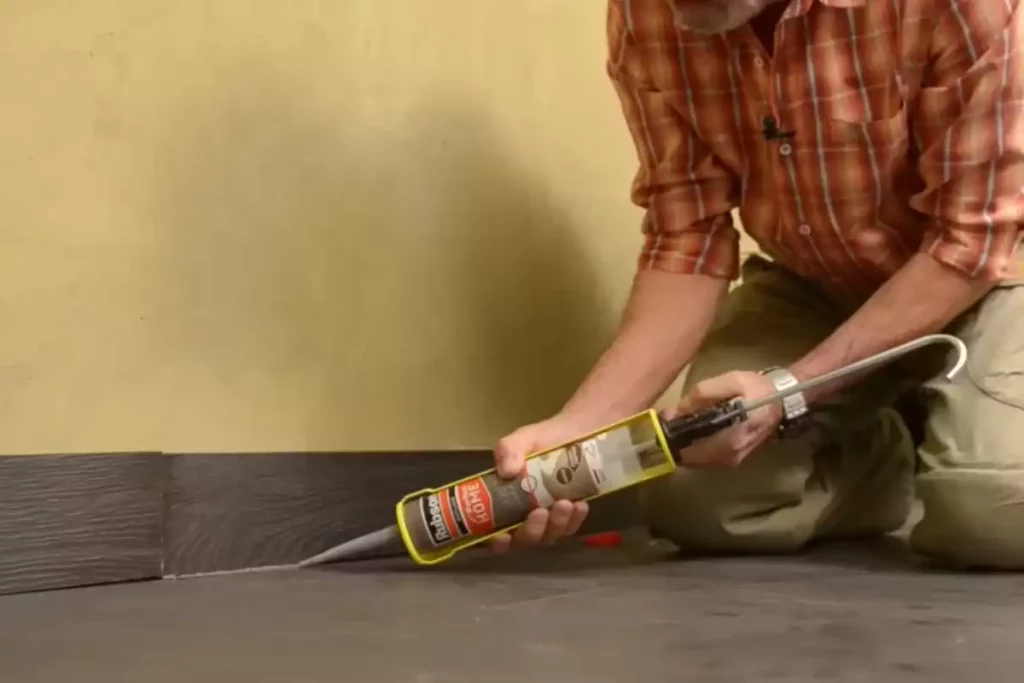 Lissage du joint acrylique entre plinthe et parquet pour une finition invisible